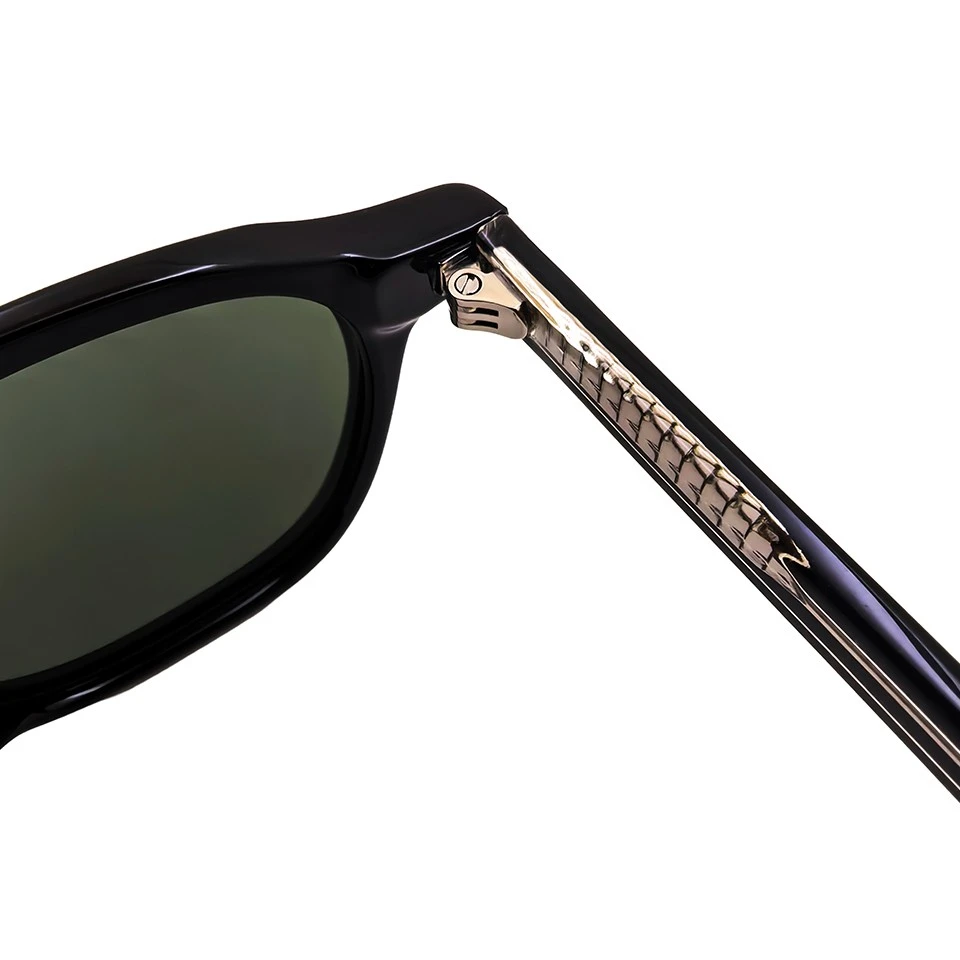 Close-up of metal hinge and engraved core wire on black acetate temple sunglasses Close-up of metal hinge and engraved core wire on black acetate temple sunglasses