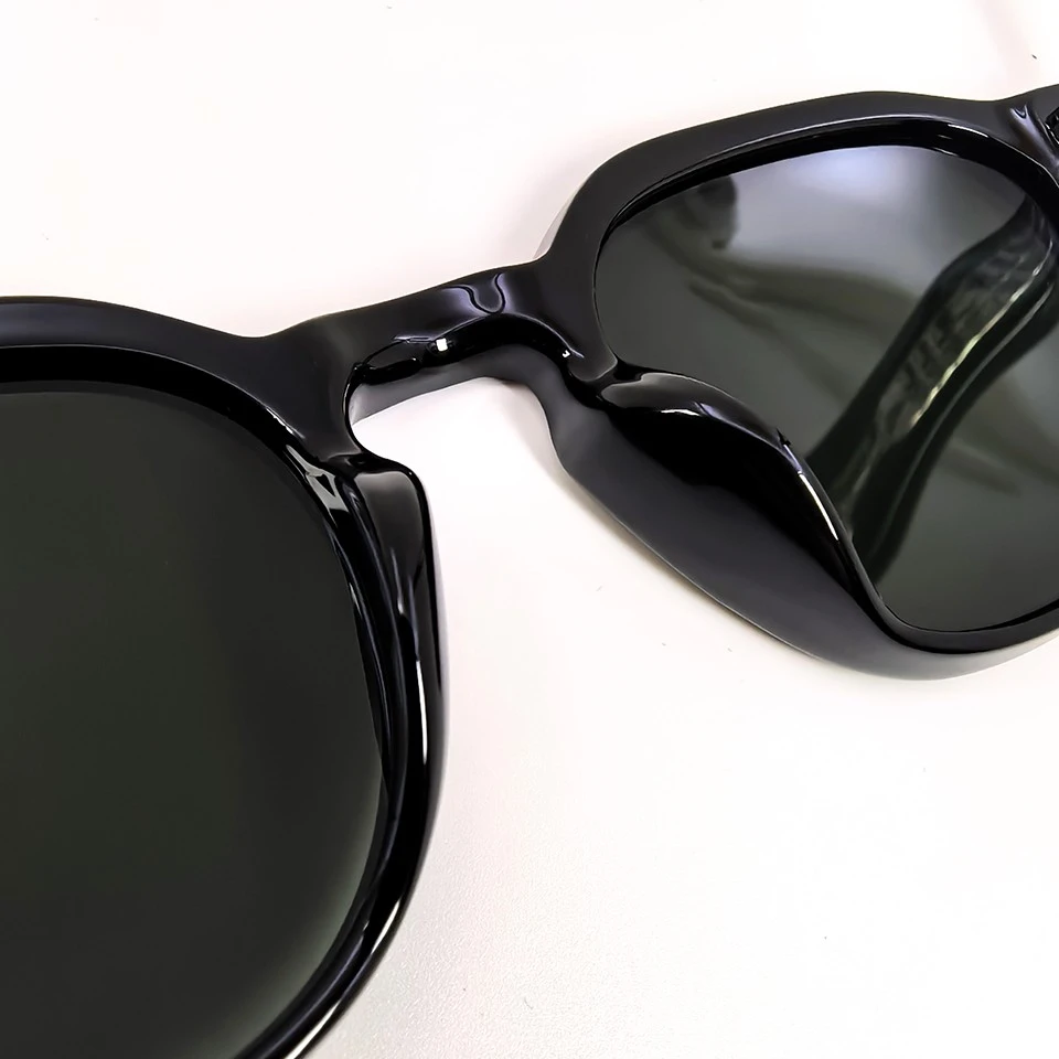 Top close-up of keyhole bridge opening on glossy black sunglasses frame Top close-up of keyhole bridge opening on glossy black sunglasses frame